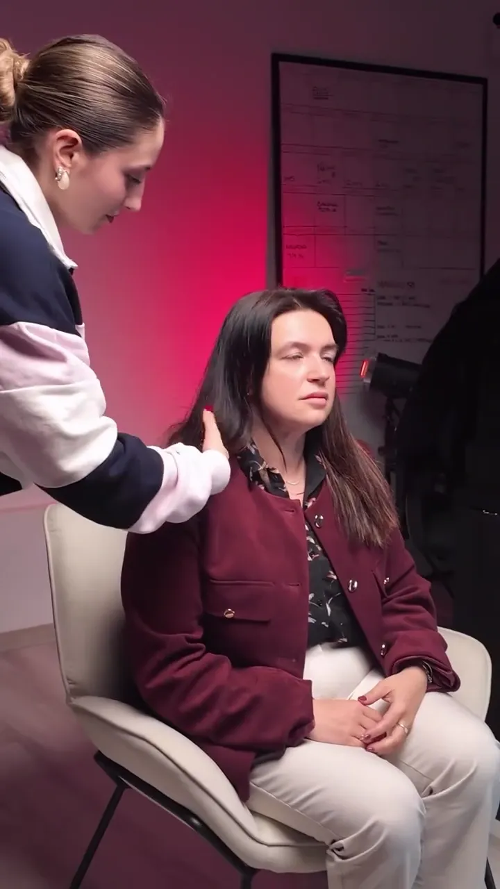 Il microfono fissato a Barbara Poltrone sul set, davanti a una parete rosa